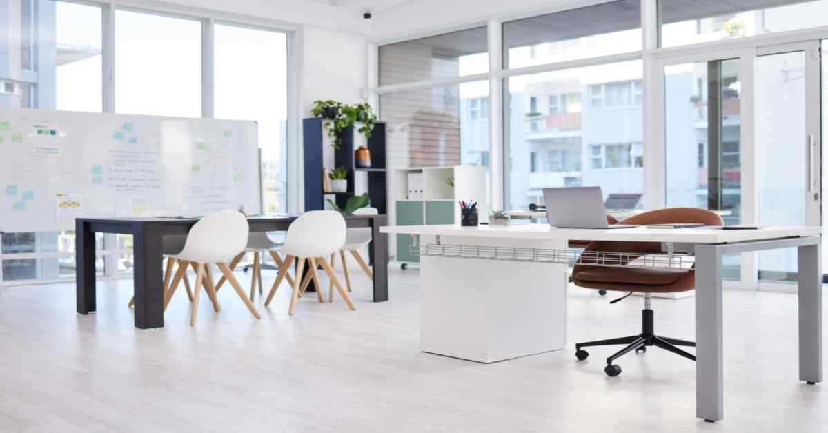 empty-white-desk-with-laptop-sits-in-a-small-bright-office